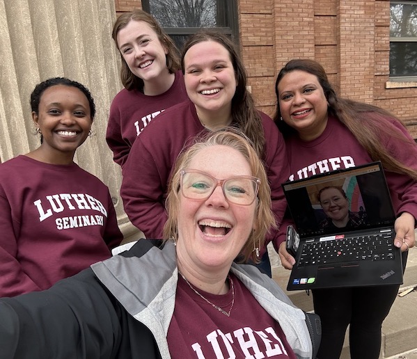 Community Life Fellows in front of Bockman Hall. (l-r) Ruth Ibrahim, Nadia Robb-Kern, Natalie Wussler, Alyssa Saleem, and Yvonne Brianne Roesel (on zoom) with Director of Student Affairs Sarah Luedtke-Jones (foreground). Not in photo: Jacob Summerville