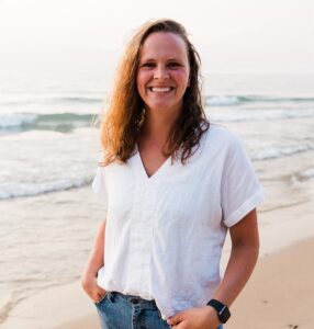 Kurty Darling, a new faculty member at Luther Seminary, standing on a beach