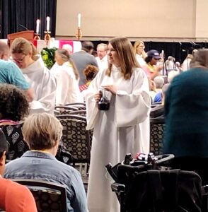 Amy Boyer assists with communion during the 2025 ELCA Churchwide Assembly in Phoenix, Arizona.